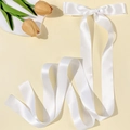 Dettaglio di un fiocco in raso bianco lucido con lunghi nastri fluenti per i capelli - Bianco