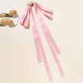 Détail de la pince à cheveux noeud en satin rose avec de longs rubans élégants - Rose
