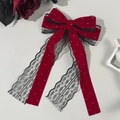 Dettaglio del fermaglio a fiocco in velluto rosso con pizzo nero e perle eleganti - Rosso