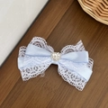 Dettaglio ravvicinato del fermaglio per capelli con fiocco in pizzo blu e strass a cuore - Blu Stile 1