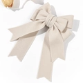 Detail einer eleganten cremefarbenen Haarschleife mit Wolltextur und langen Bändern - Beige