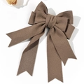 Detail einer großen braunen Haarschleife aus Stoff mit eleganten Bändern und Textur - Khaki