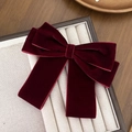 Close-up of elegant burgundy velvet double bow hair clip on a beige jewelry display box - Burgundy