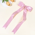 Détail d'une pince à cheveux avec nœud en satin rose et longs rubans soyeux - Rose