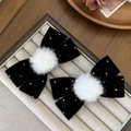 Vue détaillée de nœuds à cheveux en velours noir avec strass brillants et pompons blancs - Noir