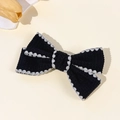 Detalle de lazo de pana negra con encaje blanco sobre una superficie crema - Estilo 2(2#)
