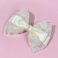 Elegant oversized cream lace bow hair clip with satin ribbon for women on pink background - Beige