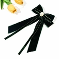 Close-up of a dark green velvet bow hair clip with a centered pearl and golden base - Dark Green