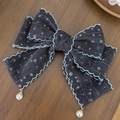 Dettaglio del fermaglio per capelli a fiocco in denim grigio con pizzo e perle - grigio scuro