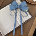 Detalle de pinza para el pelo con lazo de denim azul, etiqueta dorada Chanceux y costuras - Azul claro