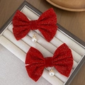 Pair of red velvet bow hair clips with gold rings and faux pearl pendants on beige tray - No.3 With Pearl Pendant Style