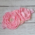 Vue détaillée du bandeau pour bébé avec fleurs en tissu rose, perles et plumes blanches - Rose Clair