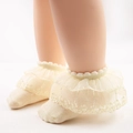 Beige Baby Socken mit Spitzenbesatz, Blumenstickerei und Rüschen am Modellfuß - Beige