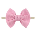 Detailed close-up of pink waffle texture fabric bow on beige nylon headband for babies - Light Pink