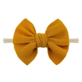 Detailed view of ginger yellow waffle texture bow on stretchy nylon baby headband - Turmeric