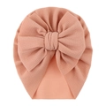 Close-up of peach pink infant turban hat featuring ribbed texture and a large bow detail - One Size / Blush
