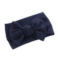 Detail eines dunkelblauen Baby-Stirnbands aus Rippstrick mit einer großen strukturierten Schleife - Marineblau