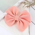 Handmade coral pink waffle textured bow hair clip for infants on white silk background - Off White