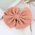 Pink waffle texture knit bow hair clip for girls placed on a soft white silk background - Blush
