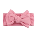 Detailed view of soft pink ribbed knit baby headband with a large decorative bow - Pink