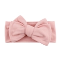 Close-up of pink ribbed baby headband featuring a large soft bow and elastic knit texture - Blush