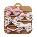 Close-up of five handmade baby bow headbands with floral and lace patterns on craft card - Style 11