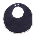 Detail of navy cotton gauze baby bib with pom-pom trim and adjustable snap buttons - Navy Blue