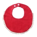 Close-up of soft red cotton gauze baby bib with white pom-pom trim and snap buttons - Red