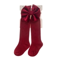 Detail of burgundy ribbed baby socks featuring a large velvet bow on brand packaging - Small (0-12m) / Burgundy