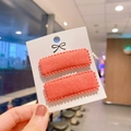 Close-up of rectangular pink matte fabric hair clips with wavy edge details - Coral Pink (PP180-19)