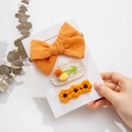 Gros plan d'un ensemble de barrettes à fleurs en tricot orange faites à la main sur carte - Style Orange à Pois (DP105-5)