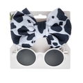 Detail of baby headband with cow pattern bow and cat ear sunglasses on a white card - White Sunglasses And Cow Print Headband