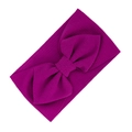 Elastic deep purple baby headband featuring a large bow and waffle textured fabric - Fuschia