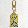 Macro shot of yellow enamel evil eye keychain featuring engraved I SEE YOU text details - Yellow
