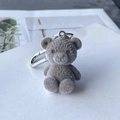 Cute dark gray flocked teddy bear keychain with silver metal hook on white surface - Dark Brown