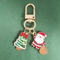 Détail du porte-clés de Noël avec breloques Père Noël et sapin en métal émaillé doré - Sapin de Noël à Nœud et Père Noël