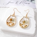 Detailed close-up of a cat-shaped earwire drop with dried flowers and gold foil accents - White Flower Star Cat