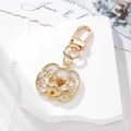Halloween pumpkin keychain featuring yellow dried flowers and gold leaf in resin - White Floral Big Pumpkin