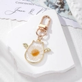 Cat-shaped resin keychain with dried daisy flower, gold wings, and premium gold metal hook - White Flower Winged Cat