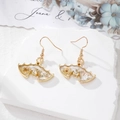 Boucles d'oreilles chauve-souris dorées avec résine et fleurs séchées sur marbre - Chauve-souris Fleur Blanche