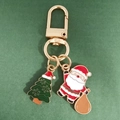 Detailed view of enamel Christmas tree and Santa Claus pendants on a gold keychain - Christmas Tree And Santa