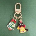 Detail of Christmas cat keychain with enamel tree charm on dark green background - Bow Christmas Tree and Bell Black Cat