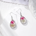 Detail of drop-shaped resin earrings with real pink dried flowers on a white stone - Rose Red Narcissus Lace Flower