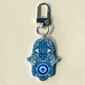 Macro detail of Hamsa Hand keychain with blue evil eye mandala pattern on acrylic - Blue Round Eye Hand