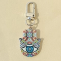 Macro shot of Hamsa hand keychain with bohemian patterns and Evil Eye center design - Colorful Blue Eye Print Hand