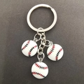 Détail de trois pendentifs de baseball miniatures avec coutures fines et porte-clés argentés - Baseball Compact