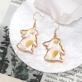 Macro shot of gold rabbit earrings featuring real white dried flowers in resin - White Daisy Rabbit
