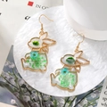 Detailed macro shot of gold rabbit earring featuring blue and green real dried flowers - Green Flower Rabbit