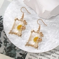 Close-up of gold rectangle drop earrings with white dried daisy flowers in resin - Square Half White Daisy