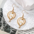 Detailed close-up of handmade gold hot air balloon earrings with white dried flowers - Star White Flower Hot Air Balloon